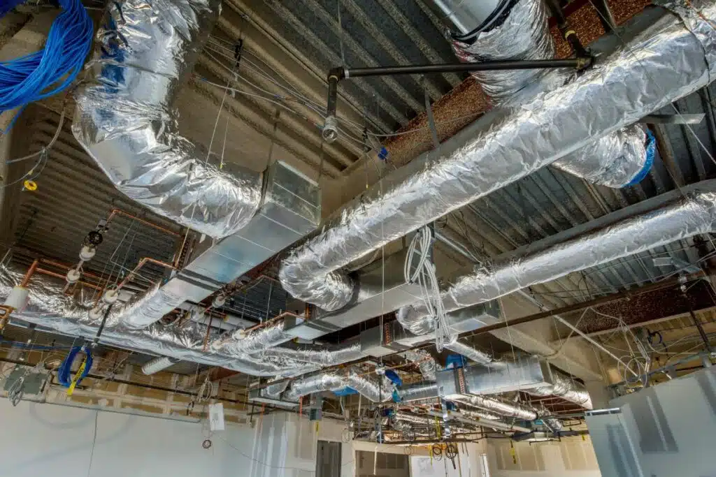 Luchtbehandelingsinstallatie met ventilatiekanalen en luchtkanalen voor optimale klimaatbeheersing in kantoorgebouw.