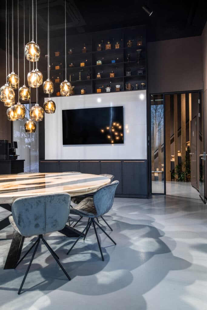Vergaderruimte bij Coffeeclick met luxe designlampen, marmeren tafel en moderne stoelen, ingericht door E=MC²