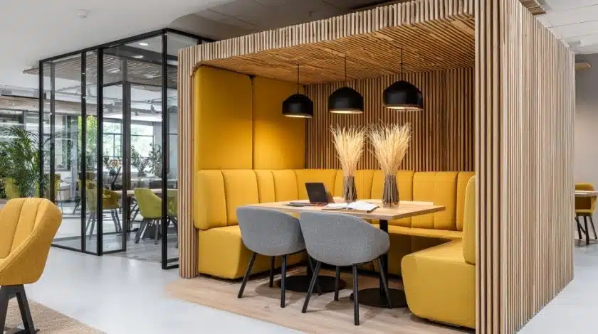 Akoestische vergaderunit met houten lamellen en gele banken, moderne kantoorinrichting