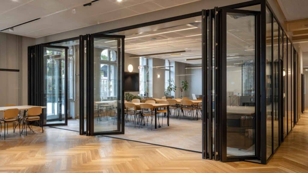 Glazen schuifwand in modern kantoor voor flexibele indeling van vergader- en werkruimtes
