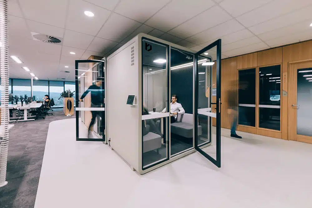 vrijstaande belcel in open kantoorruimte met glazen deur