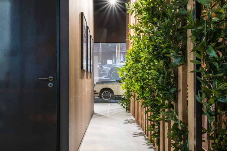 Sfeervolle doorgang bij Coffeeclick kantoor met groenwand en houten lamellen, gerealiseerd door E=MC²