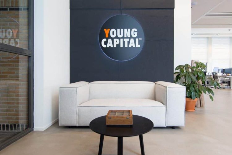 Moderne ontvangstruimte in kantoor YoungCapital met logo en projectinrichting
