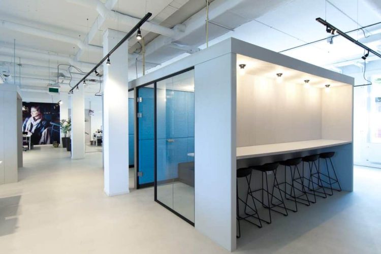 Moderne kantoorinrichting bij YoungCapital met barzit werkplek en glazen vergaderruimte, gerealiseerd door E=MC²